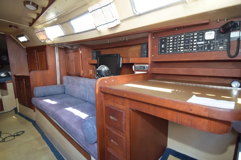 Slide: The Image of Interior of a 1991 Catalina 38 sailboat with wood paneling and a cozy seating area. - 6