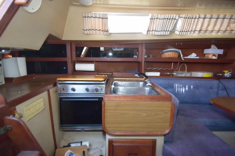 Slide: The Image of 1991 Catalina 38 yacht interior with kitchen, stove, sink, and seating area. - 4