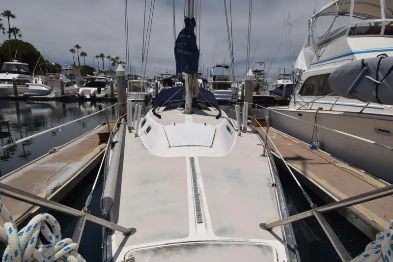 Slide: The Image of 1991 Catalina 38 sailboat docked in a marina, surrounded by other boats. - 17