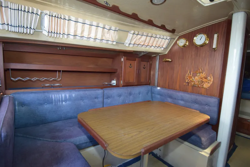 Slide: The Image of Interior of a 1991 Catalina 38 sailboat with a cozy dining area and wooden accents. - 7