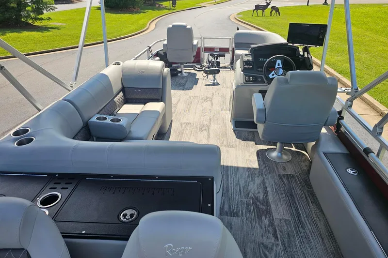 Slide: The Image of 2024 Ranger Reata 220FC boat interior with gray seating and modern dashboard. - 16