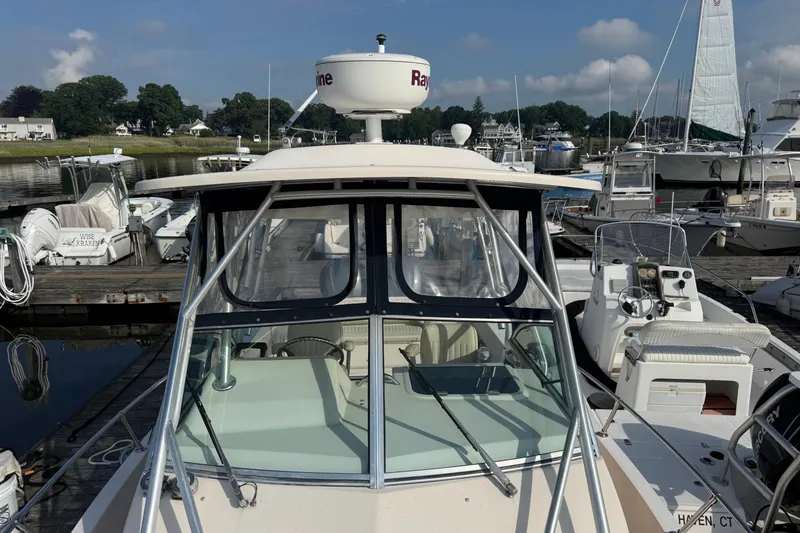 Slide: The Image of 2005 Grady-White Gulfstream 232 boat docked at marina, clear sky background. - 4