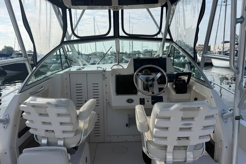 Slide: The Image of 2005 Grady-White Gulfstream 232 boat interior with helm and seating at marina. - 6