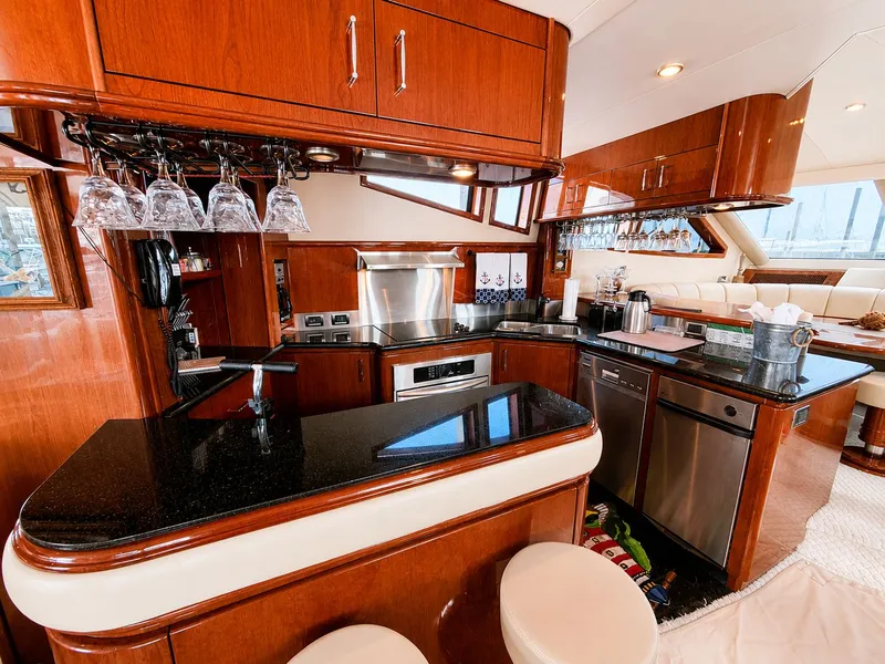 Slide: The Image of The luxurious galley of a 2006 Marquis 65 yacht with wood paneling and modern appliances. - 8