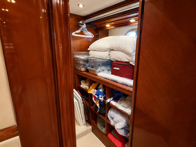 Slide: The Image of A well-organized wooden closet filled with pillows, blankets, and clothing. - 26