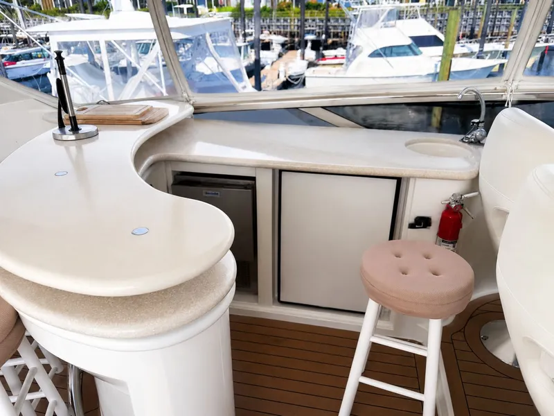 Slide: The Image of The 2006 Marquis 65 yacht features an elegant bar with stools, overlooking a marina. - 45