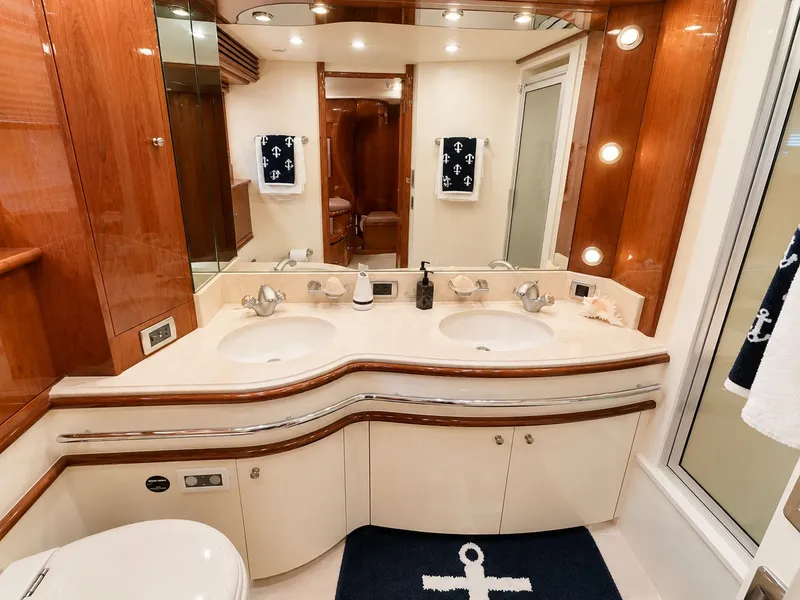 Slide: The Image of Luxurious bathroom with double sinks, wood paneling, and nautical details on a Marquis 65 boat. - 30