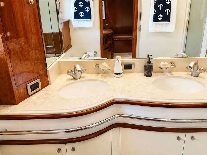 Slide: The Image of The image shows a luxurious yacht bathroom with dual sinks and wood paneling. - 28