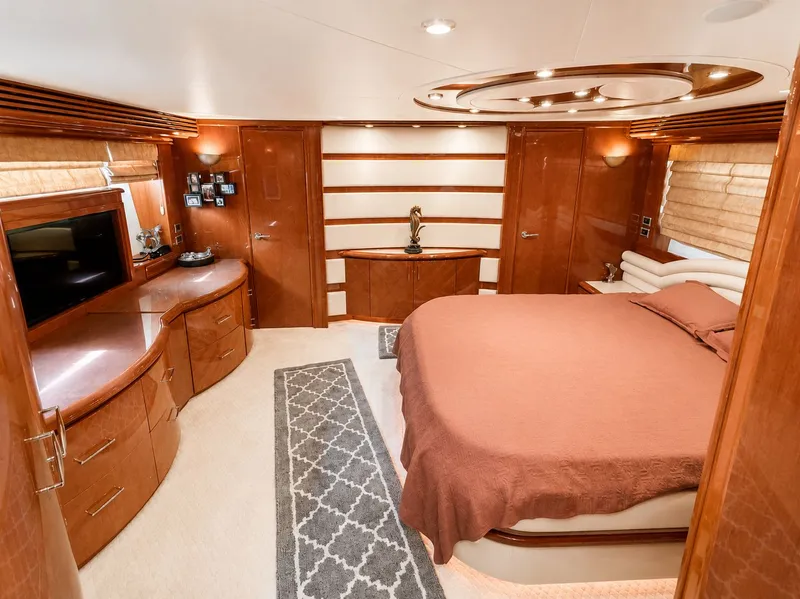 Slide: The Image of Luxurious cabin with a large bed, wooden furnishings, and a wall-mounted TV. - 32