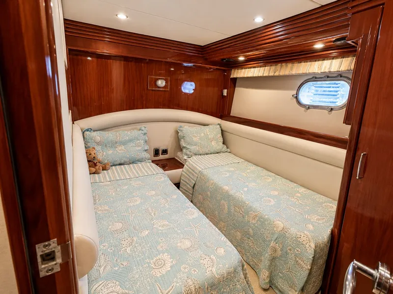 Slide: The Image of The 2006 Marquis 65 cabin features two single beds with blue bedding and wooden walls. - 25