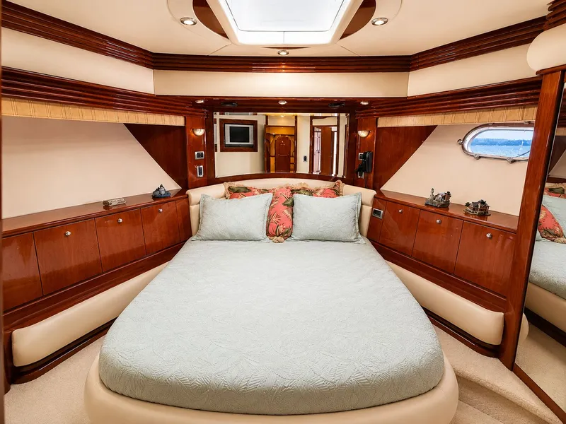 Slide: The Image of Luxurious cabin with a large bed, wooden furnishings, and a porthole letting in daylight. - 22