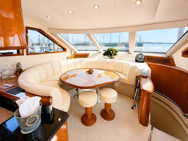 Slide: The Image of The interior of a 2006 Marquis 65 features an elegant seating area with cream upholstery and a wooden table. - 13