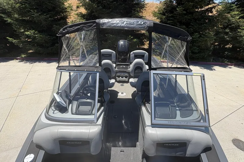 Slide: The Image of 2018 Tracker Targa V-18 Combo boat with seating and canopy, parked outdoors. - 10