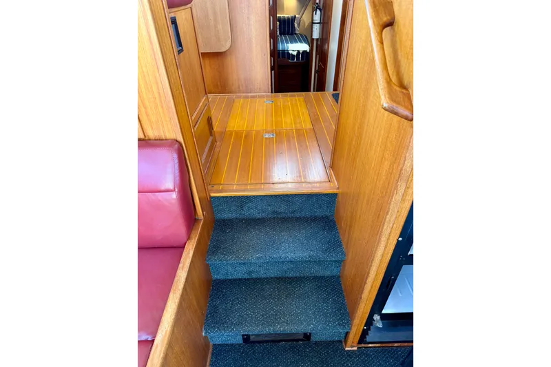 Slide: The Image of Interior stairs of a 2000 Nordic Tug 37, featuring wood paneling and carpeted steps. - 59
