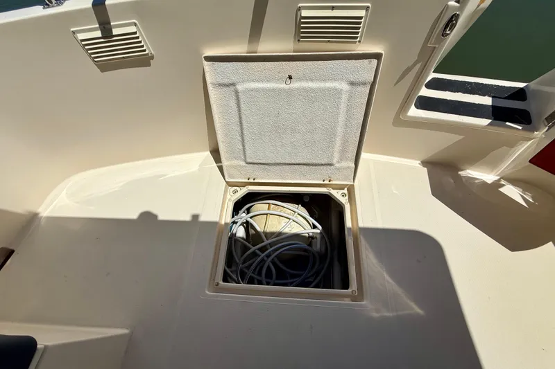 Slide: The Image of Open hatch on 2000 Nordic Tug 37 boat deck, revealing coiled cables inside. - 73