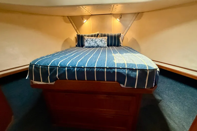 Slide: The Image of Cozy cabin interior of 2000 Nordic Tug 37 with striped bedding and ambient lighting. - 44