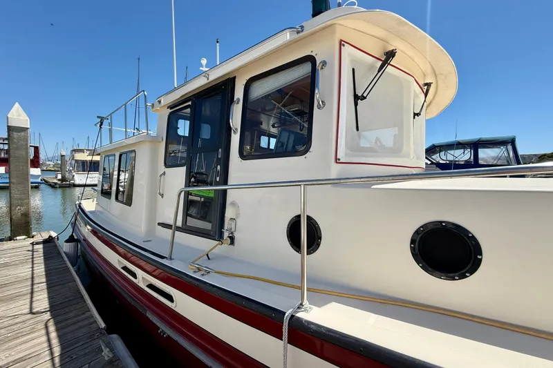 Slide: The Image of 2000 Nordic Tug 37 docked at marina under clear blue sky. - 78