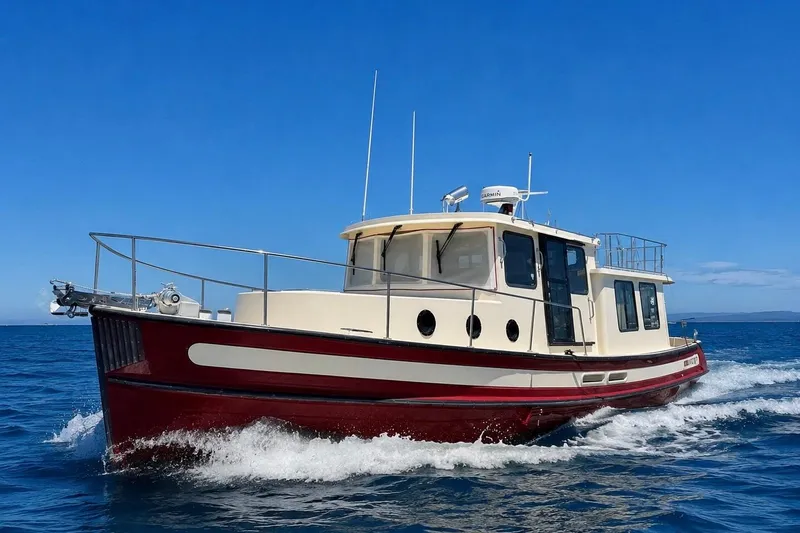 Slide: The Image of Nordic Tug 37, 2000 model, cruising on open water under clear blue skies. - 1