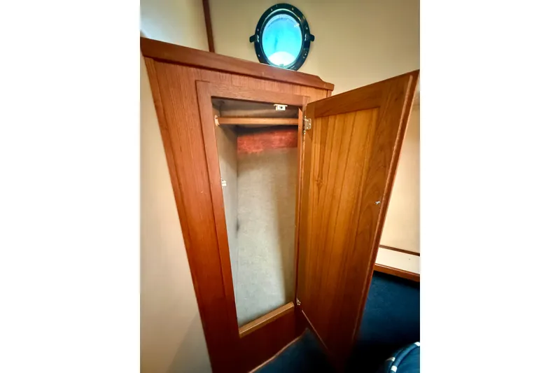 Slide: The Image of Wooden closet with open door inside a 2000 Nordic Tug 37 boat cabin. - 48