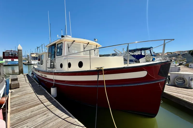 Slide: The Image of 2000 Nordic Tug 37 docked at marina under clear blue sky. - 6