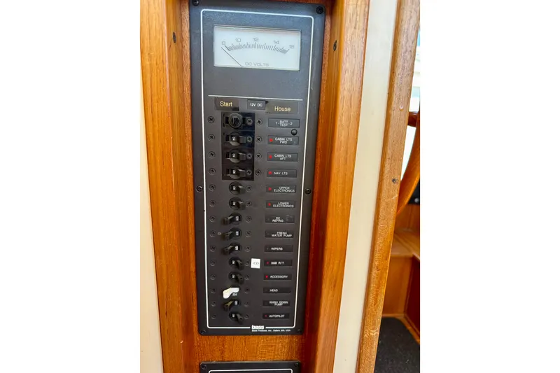 Slide: The Image of Electrical panel of a 2000 Nordic Tug 37 boat, featuring various switches and a voltmeter. - 66