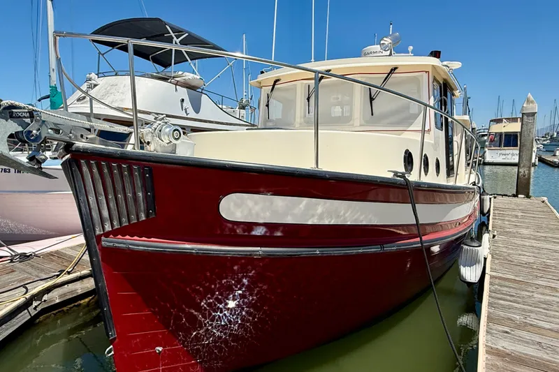 Slide: The Image of Nordic Tug 37, 2000 model, docked at marina with vibrant red hull. - 5