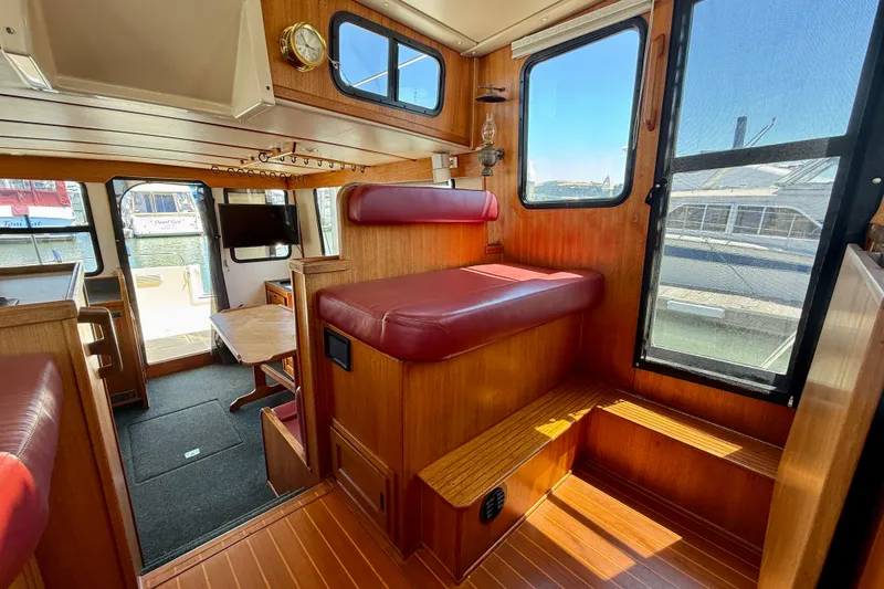 Slide: The Image of Interior of a 2000 Nordic Tug 37 with wood paneling and red seating. - 57