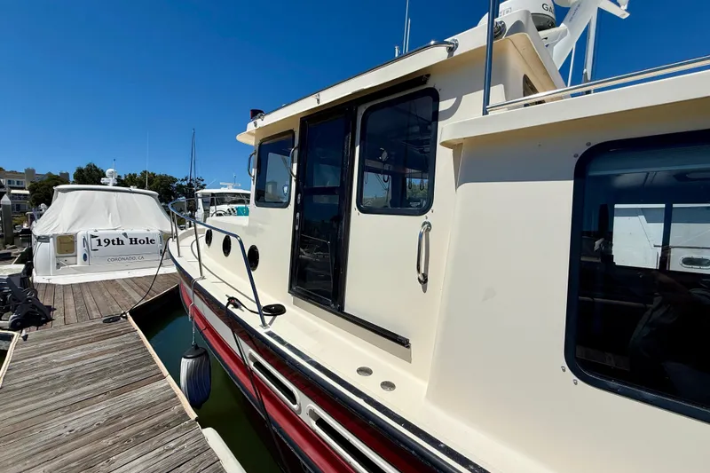 Slide: The Image of Nordic Tug 37, 2000 model, docked at marina under clear blue sky. - 75