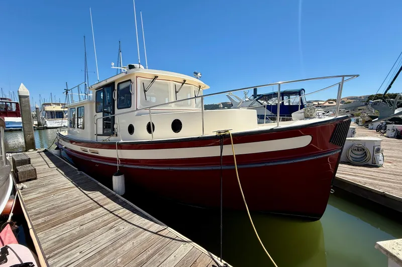 Slide: The Image of 2000 Nordic Tug 37 docked at marina under clear blue sky. - 76