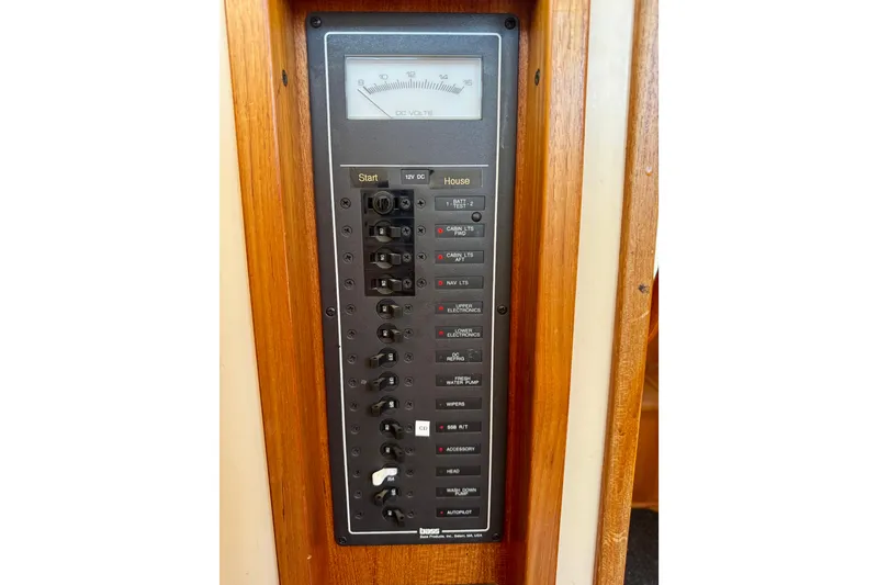Slide: The Image of Electrical panel on a 2000 Nordic Tug 37 boat, featuring various switches and a voltmeter. - 67