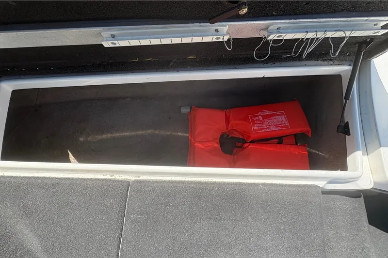 Slide: The Image of Storage compartment in a 2008 Nitro Z-7 boat with a red life jacket inside. - 22