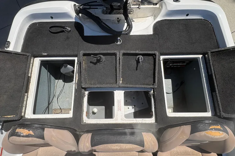 Slide: The Image of 2008 Nitro Z-7 boat interior with open storage compartments and worn seats. - 19