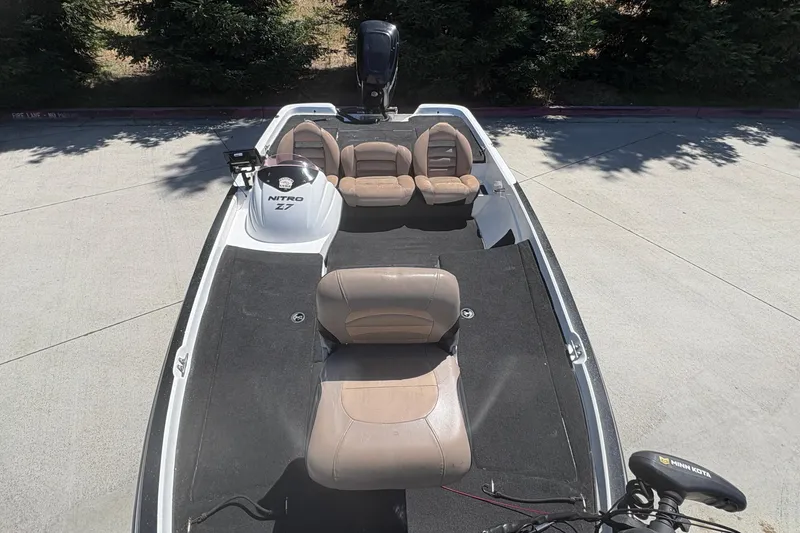 Slide: The Image of 2008 Nitro Z-7 boat with beige seats and black carpet, parked outdoors. - 18