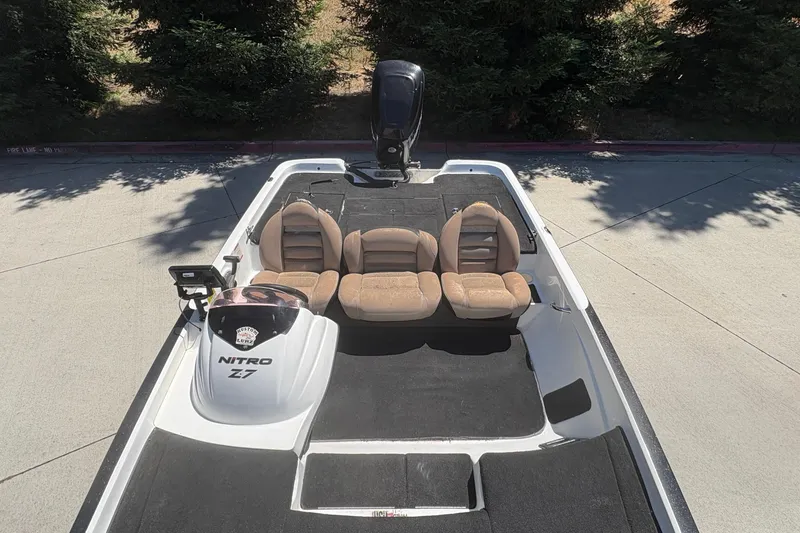 Slide: The Image of 2008 Nitro Z-7 boat with beige seats and black carpet, parked outdoors. - 17