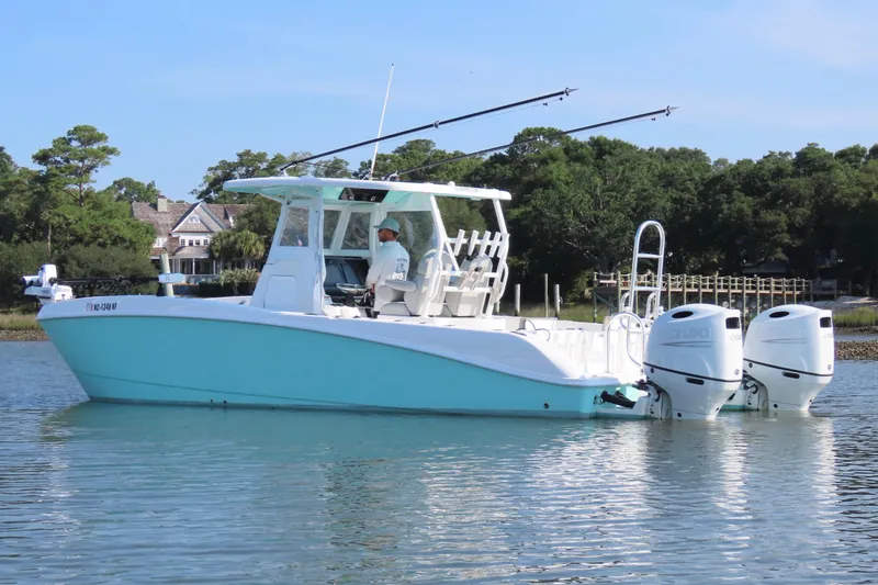 Slide: The Image of 2023 Twin Vee 260 GFX CC boat on calm water with dual engines. - 9