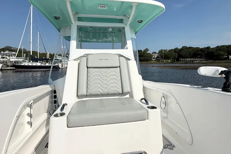 Slide: The Image of 2023 Twin Vee 260 GFX CC boat interior with seating, docked near sailboats. - 18