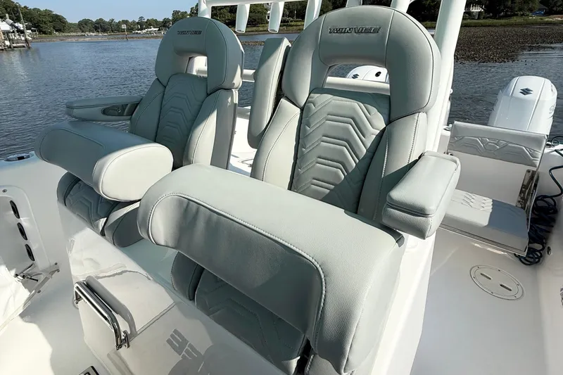 Slide: The Image of 2023 Twin Vee 260 GFX CC boat seats with armrests on a sunny day. - 14