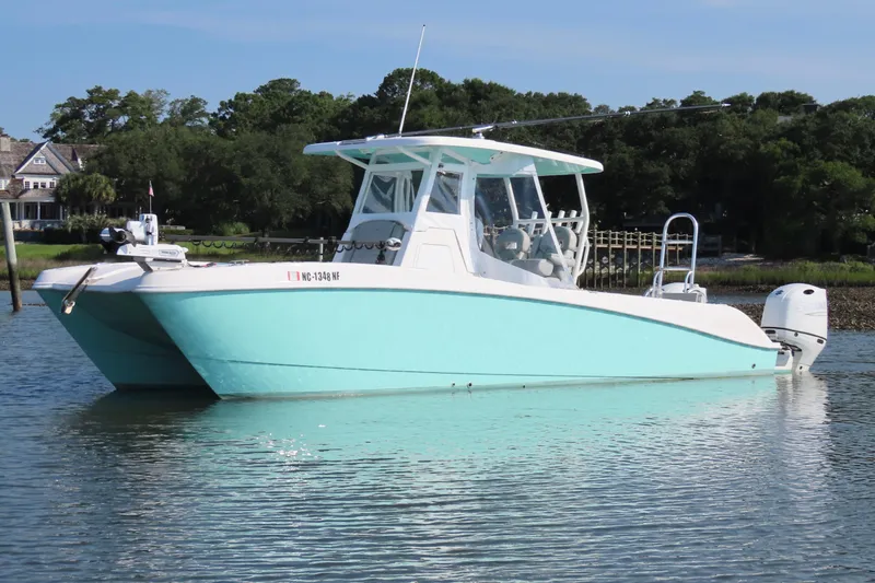 Slide: The Image of 2023 Twin Vee 260 GFX CC boat on calm water, featuring a sleek design and vibrant color. - 8