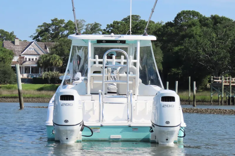 Slide: The Image of 2023 Twin Vee 260 GFX CC boat with dual engines on a serene waterway. - 4