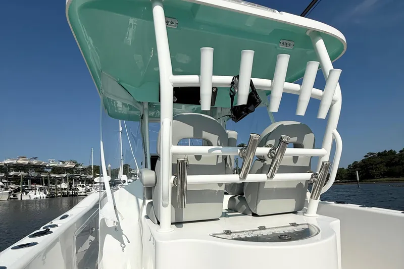 Slide: The Image of 2023 Twin Vee 260 GFX CC boat with rod holders and seating, docked at marina. - 16
