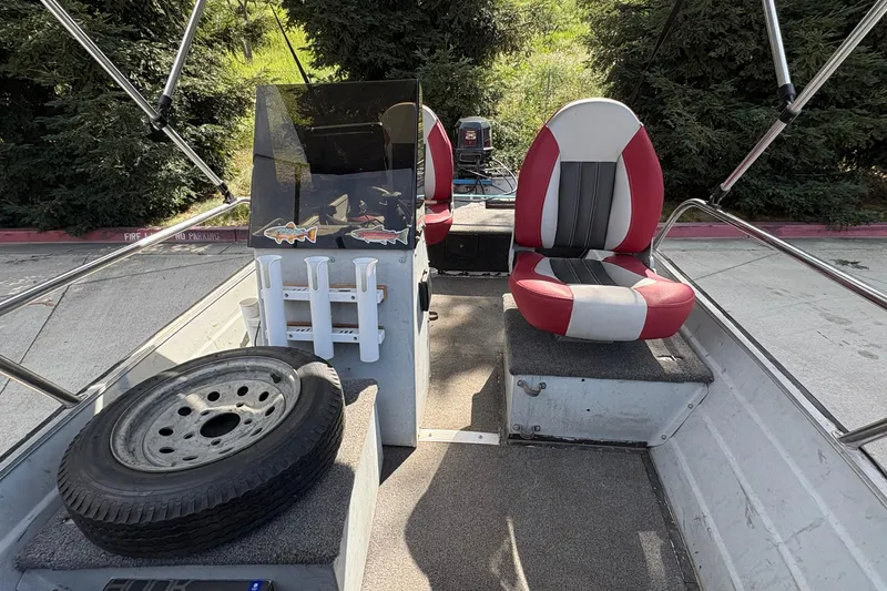 Slide: The Image of 1997 Duroboat 14rlw interior with red and white seats, spare tire, and fishing rod holders. - 20