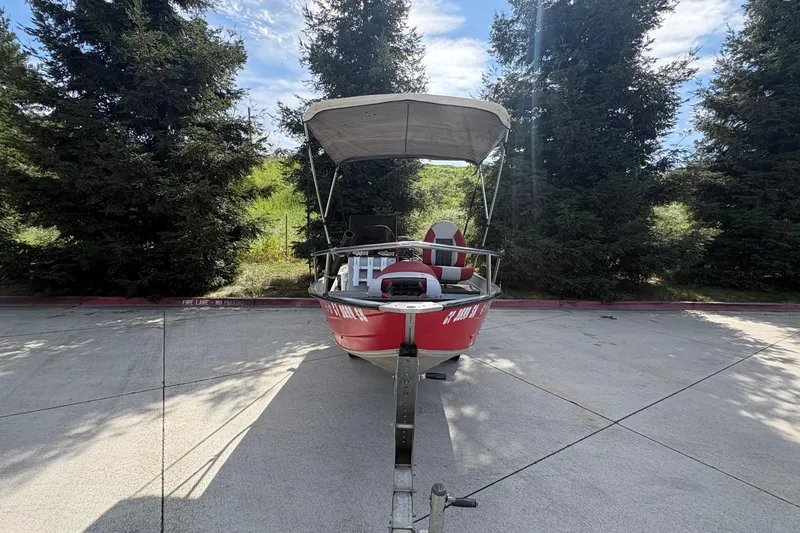 Slide: The Image of 1997 Duroboat 14rlw with canopy on trailer, parked near trees. - 21