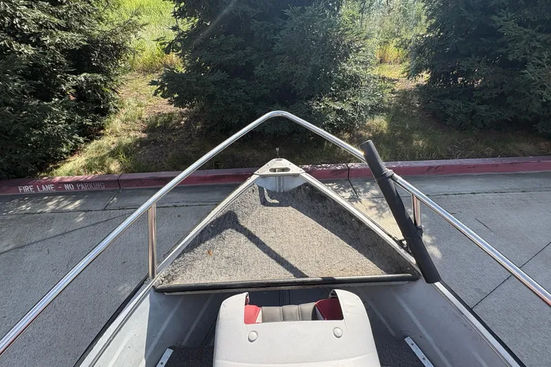 Slide: The Image of 1997 Duroboat 14rlw bow view, parked near trees and a fire lane. - 8