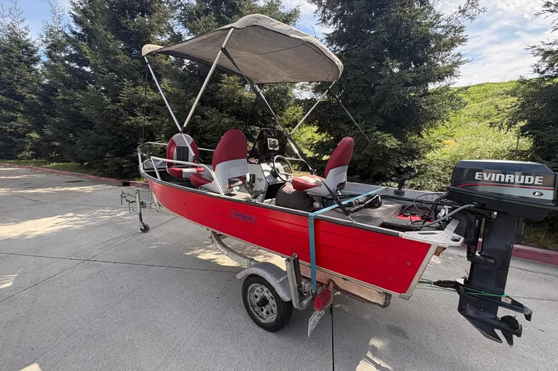 Slide: The Image of 1997 Duroboat 14rlw with Evinrude motor, red exterior, parked on trailer. - 6