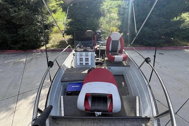 Slide: The Image of 1997 Duroboat 14rlw with red and gray seating, parked outdoors. - 19