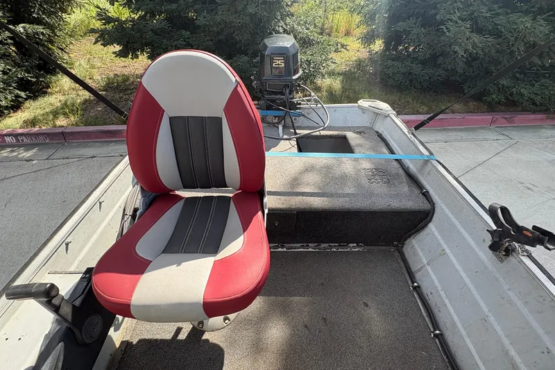 Slide: The Image of 1997 Duroboat 14rlw interior with red and white seat, motor visible. - 16