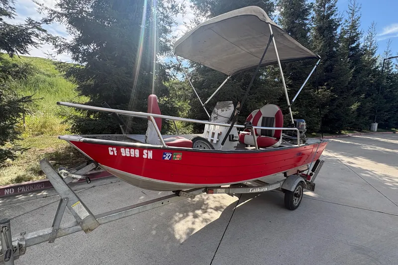 Slide: The Image of Red 1997 Duroboat 14rlw on trailer, parked outdoors with trees in background. - 4