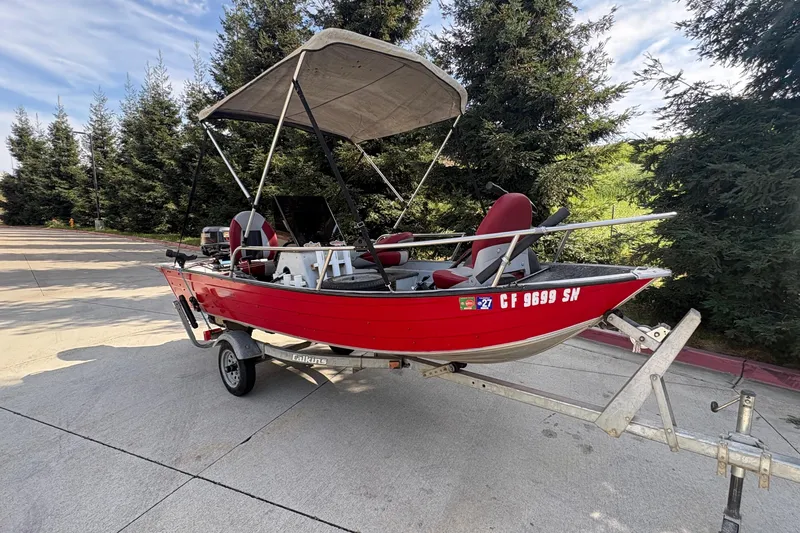Slide: The Image of Red 1997 Duroboat 14rlw on trailer, parked near trees under a clear sky. - 3