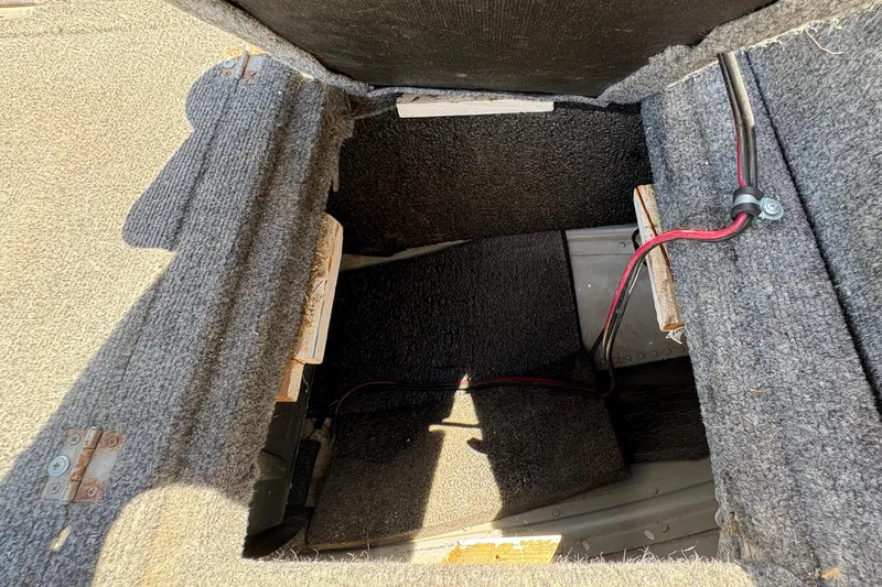 Slide: The Image of Open compartment in a 1994 Grumman 1065 vehicle, showing interior wiring and carpeted surfaces. - 17