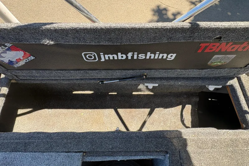 Slide: The Image of Interior of a 1994 Grumman 1065 boat with fishing gear and social media handle. - 18